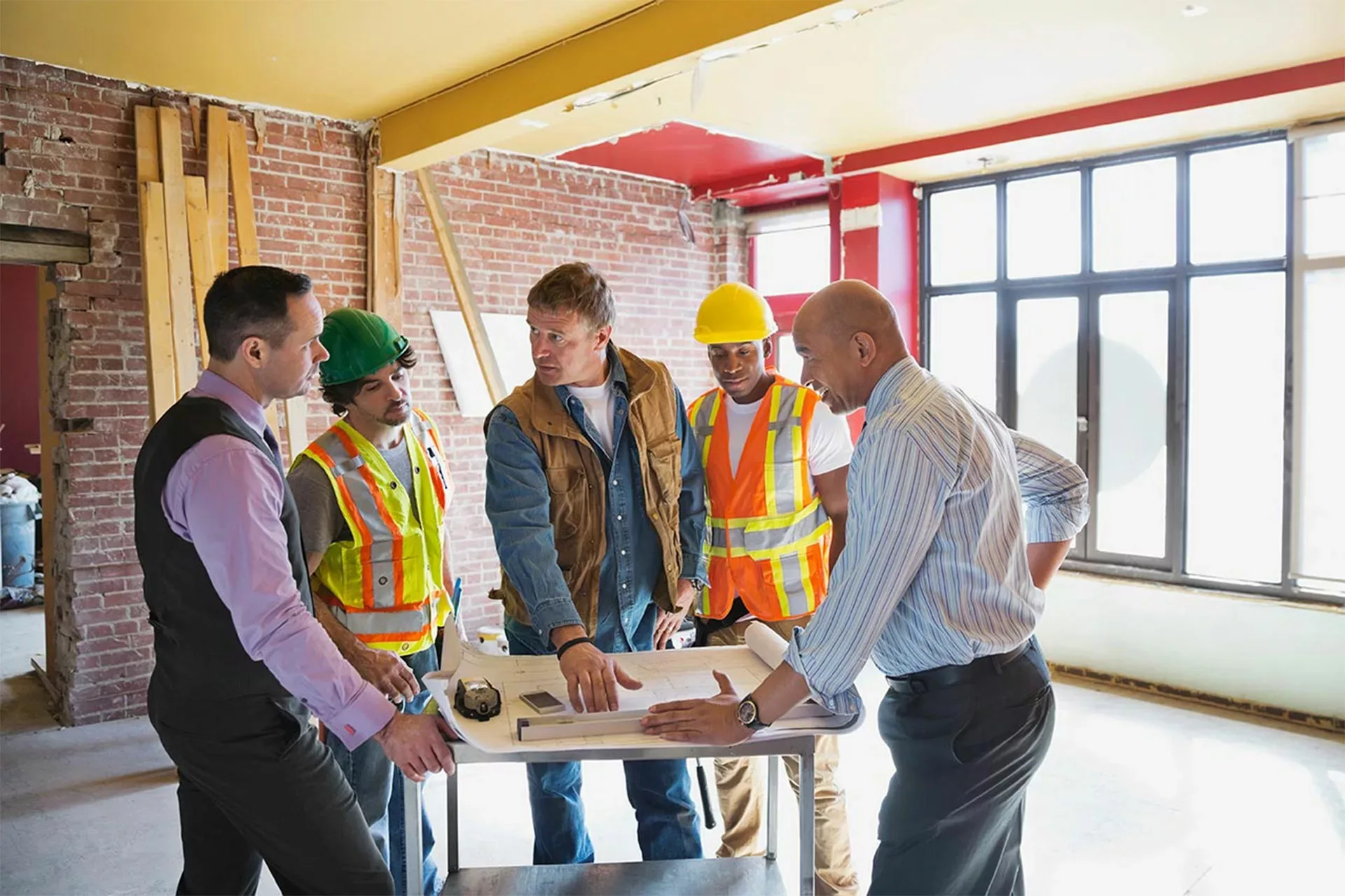 boise business owner, architect and general contractors gather together to review blueprint for commercial renovation project