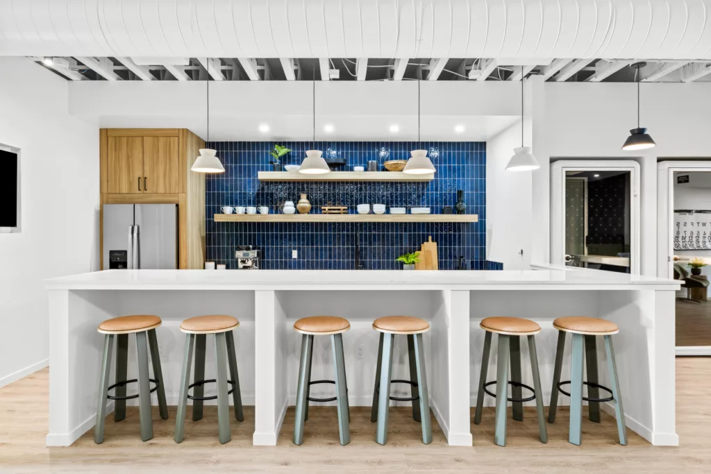 Interior of remodeled kitchen with blue tile walls, long island, appliances, and decor