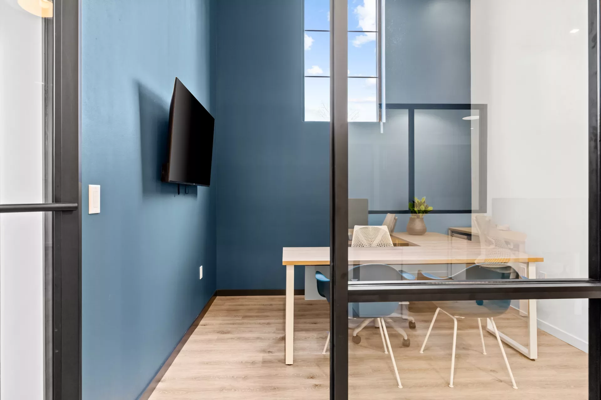 Small office with a desk, chairs, and blue and white walls